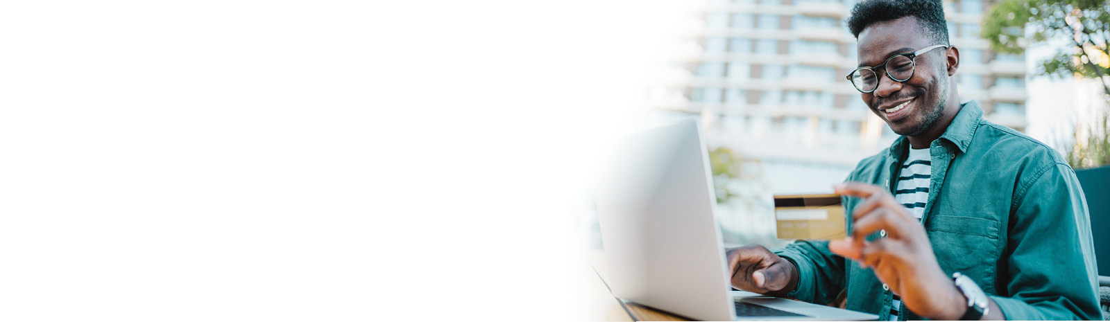 Man at his computer holding his debit card