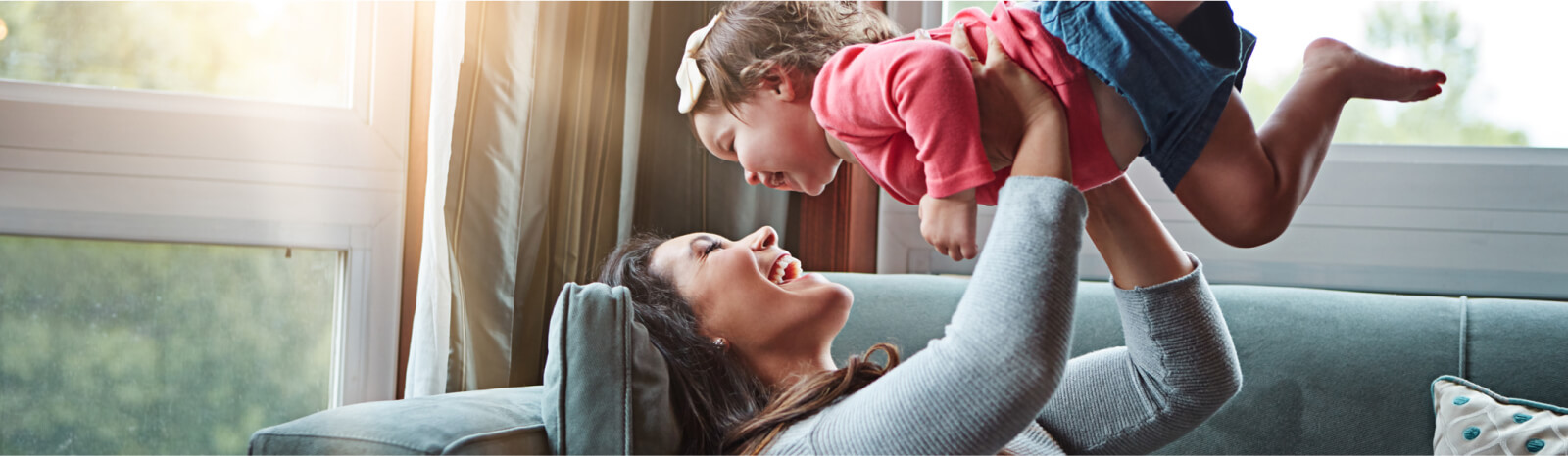 Young mom holding up a toddler