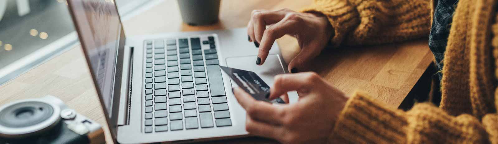 Person holding debit card while on laptop