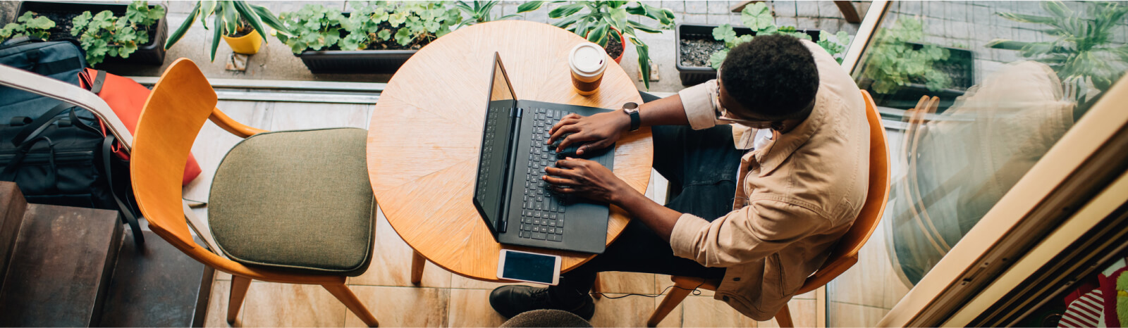 Top-down view of a person using a laptop in a cafe