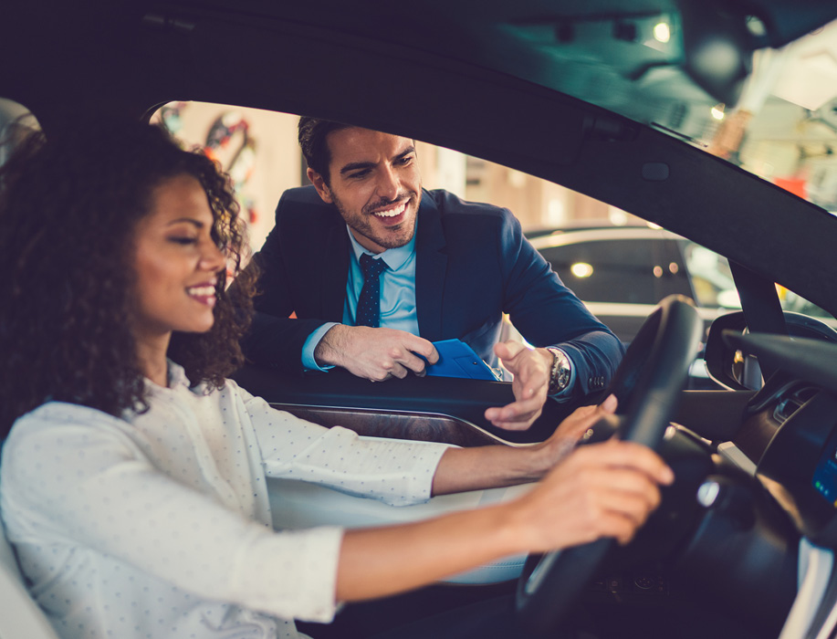 Woman in a car at a dealership